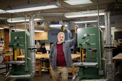 Pierratini poses next to large equipment in the Fab Lab